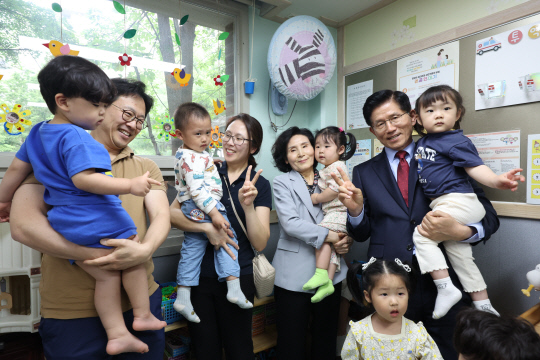 김문수 국민의힘 대선 후보와 배우자 설난영 여사, 딸 김동주 씨 부부가 22일 경기도 광명시의 한 어린이집을 방문해 어린이들과 기념 촬영하고 있다. [공동취재]